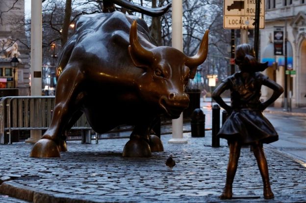 estatua de garota em pé em frente ao touro d wall street