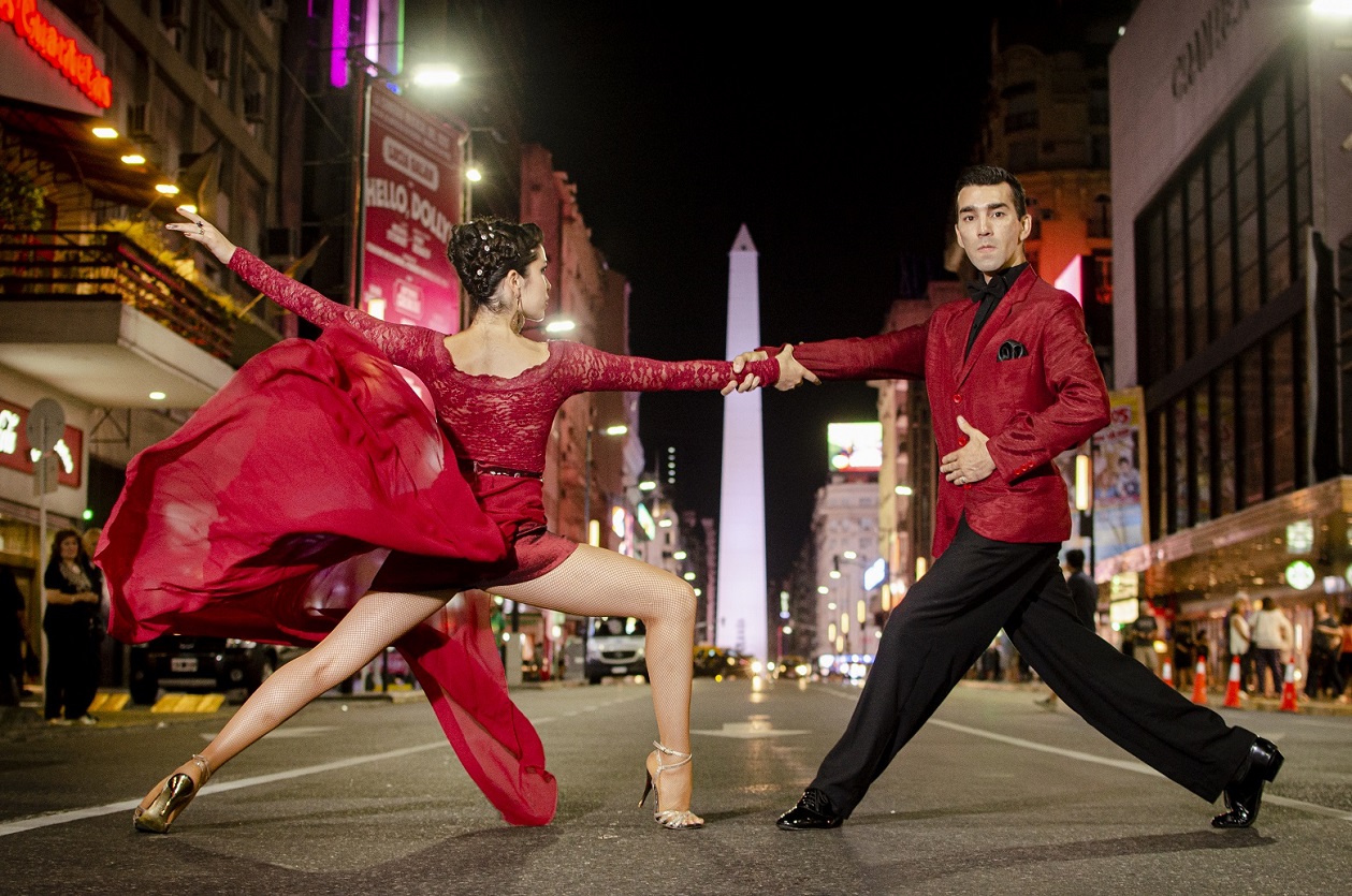 Casal de vermelho dançando tango no obelisco