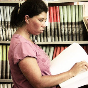 Pessoa cega lendo com livro em braille